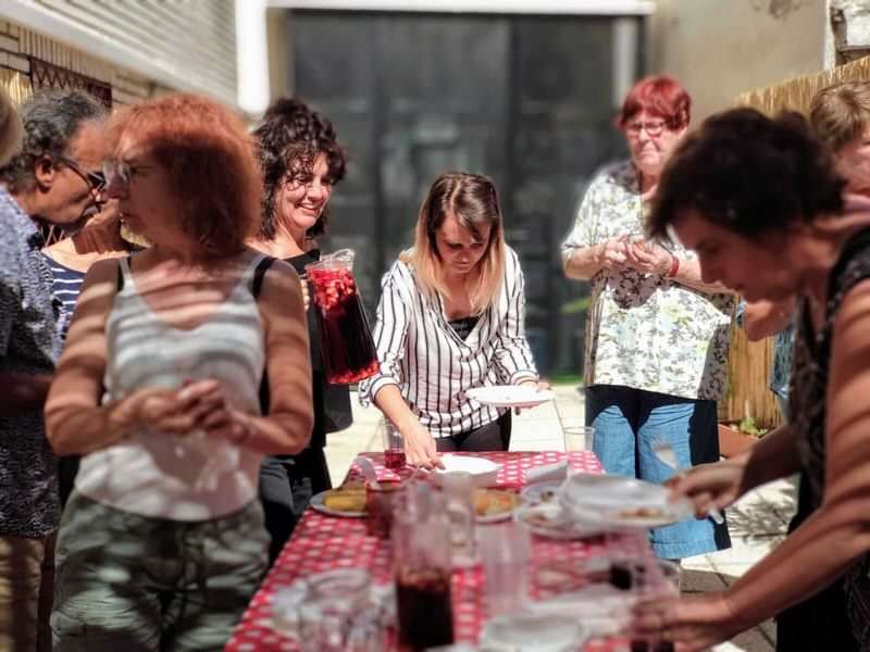Groep mensen genieten van een maaltijd tijdens taalcursus in het buitenland.