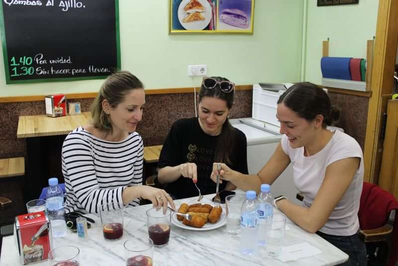 Mensen genieten van lokaal eten en oefenen buitenlandse taalvaardigheden.