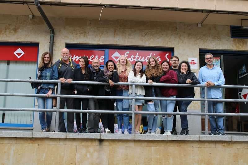 Group of students standing outside a language school on a balcony.