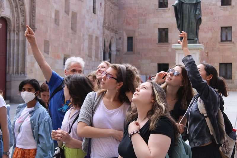 Groep toeristen luistert naar gids tijdens rondleiding in historische stad.