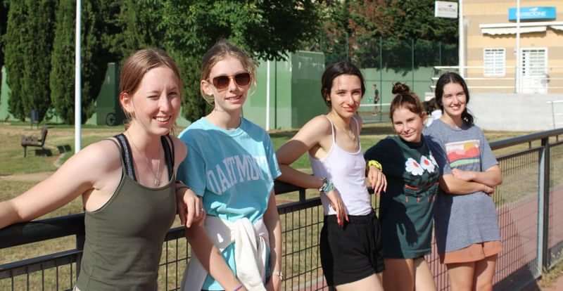 Vijf jonge vrouwen genieten van zomerkamp tijdens een taalreis.