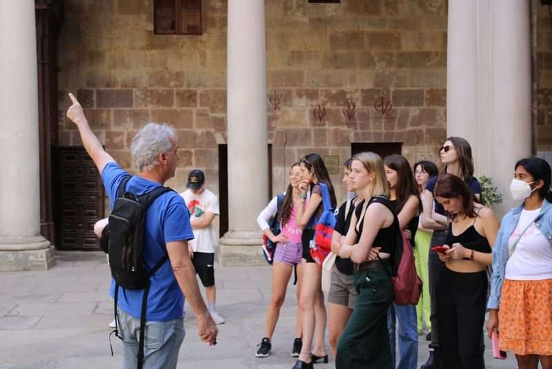 A tour group learns about local language and culture from a guide.