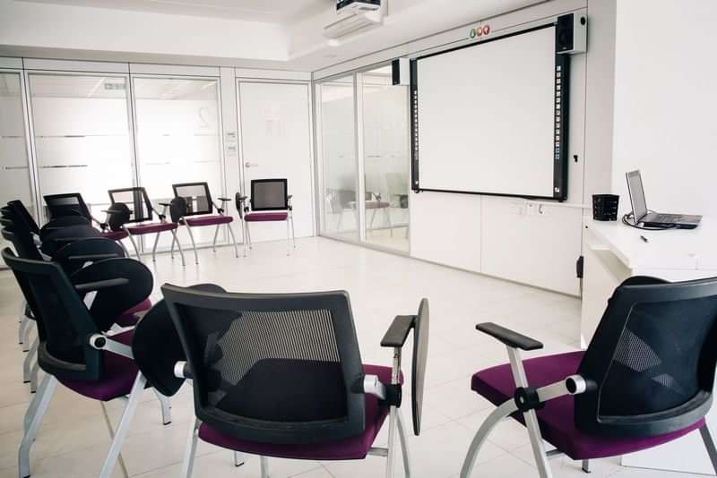 Language class setup in modern learning center with chairs and projector.