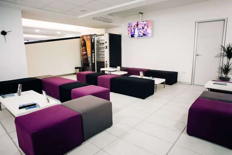 Modern language school lounge with comfortable seating and study materials.