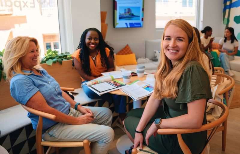 Group of people studying language travel materials, enjoying a friendly discussion.