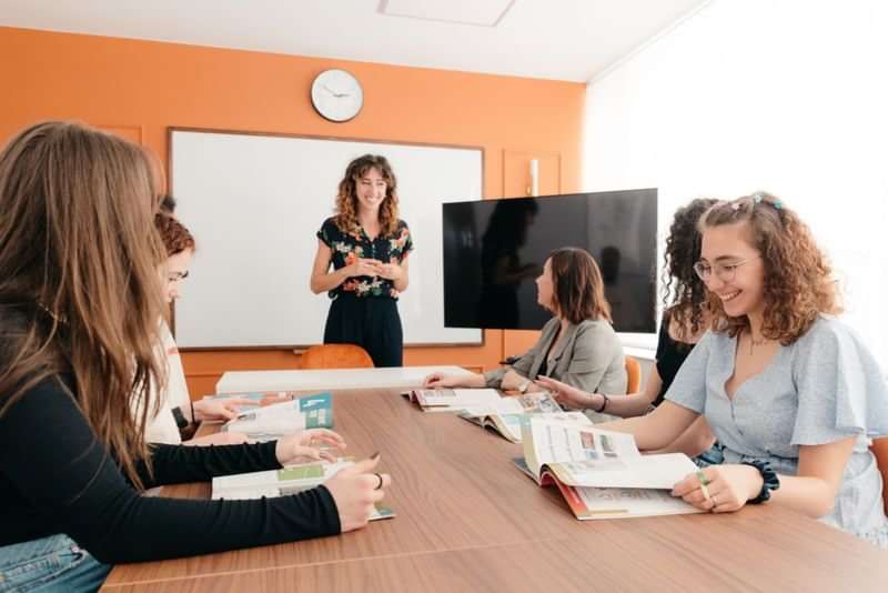 Groepsles in klaslokaal met docent en studenten, taal leren reis.