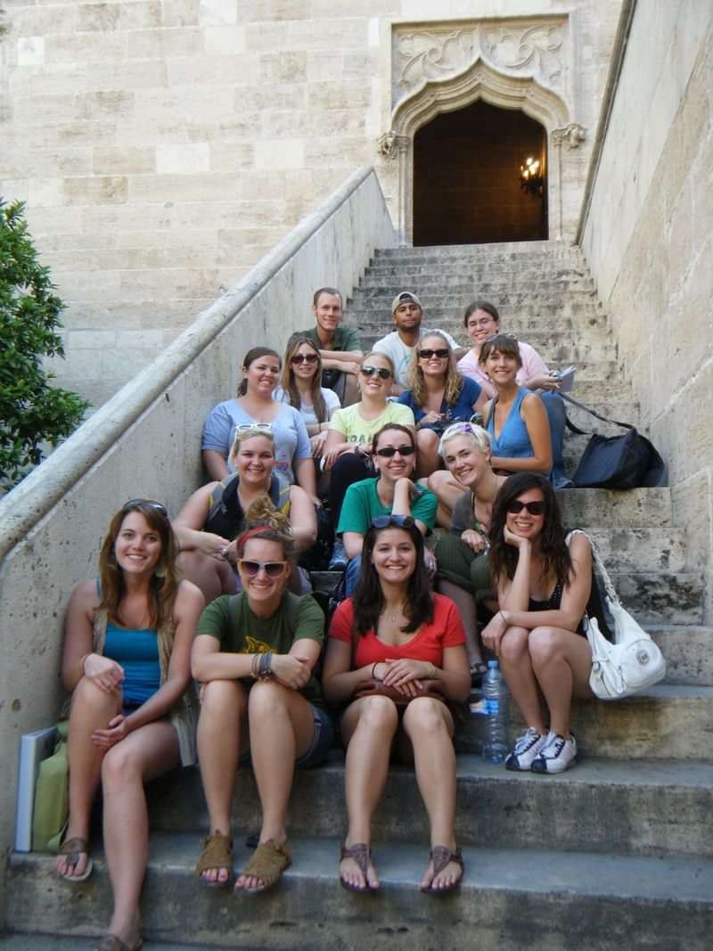 Groep jonge reizigers op een trap, mogelijk tijdens taalreis.