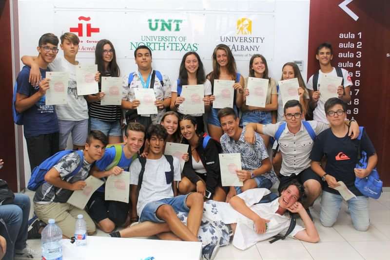 A group of students holding certificates, promoting language travel programs.
