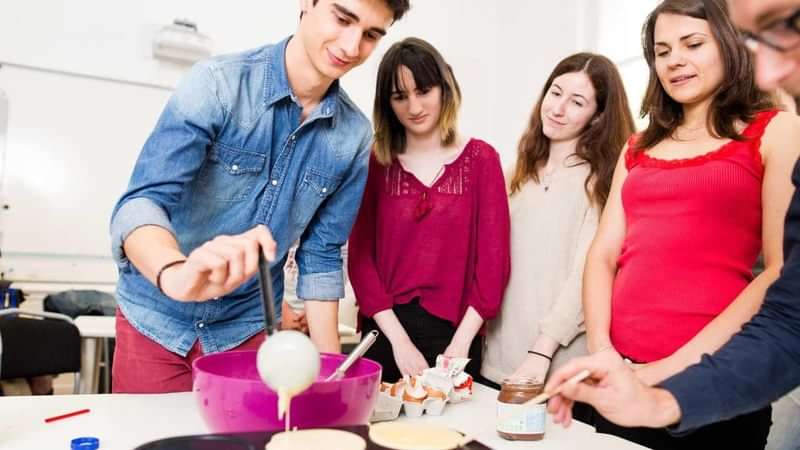 Studenten leren koken tijdens een taalcursus in het buitenland.