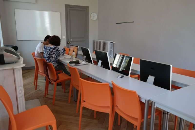 Twee mensen studeren in een klaslokaal met computers.