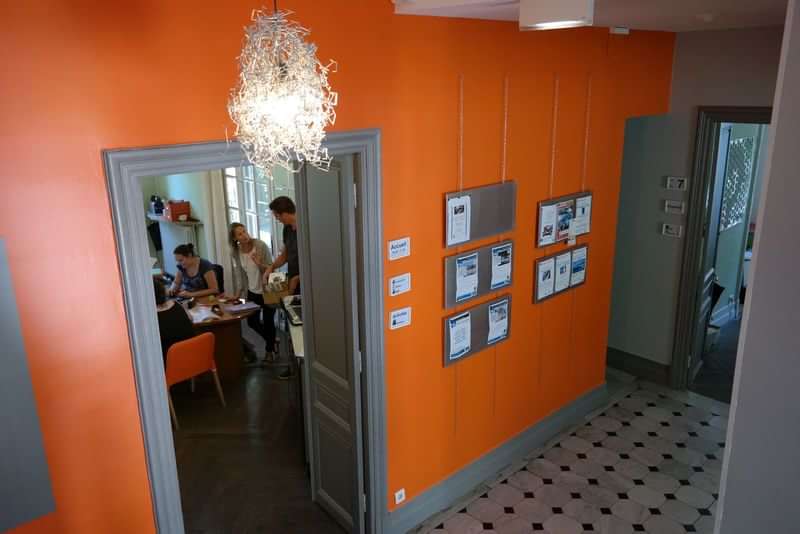People studying in a language school, hallway with information boards.