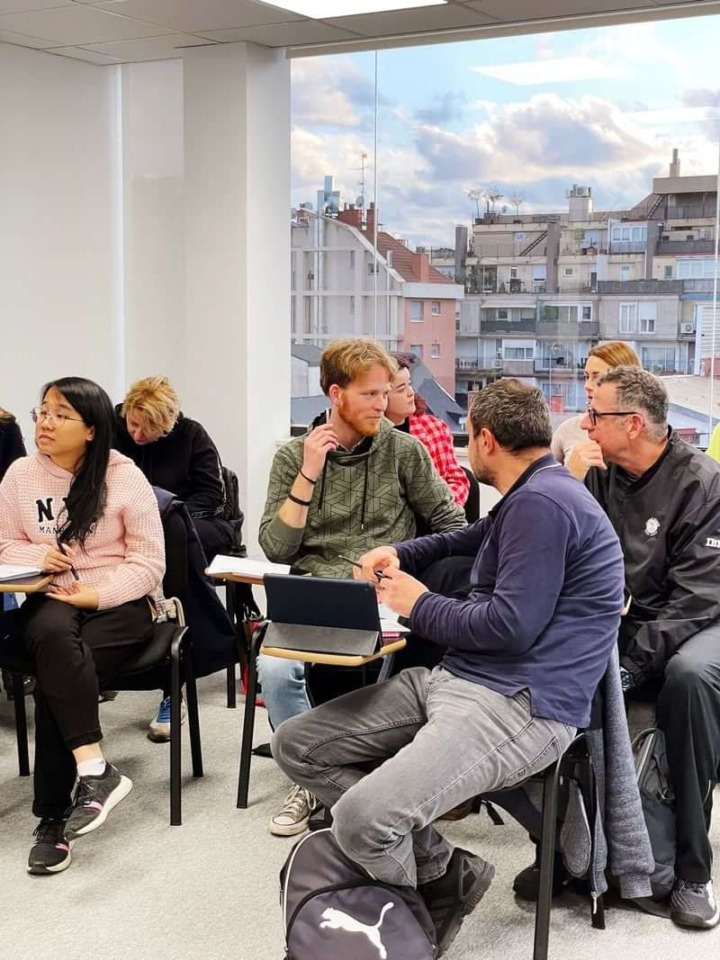 Students engaging in a language class discussion in an urban setting.