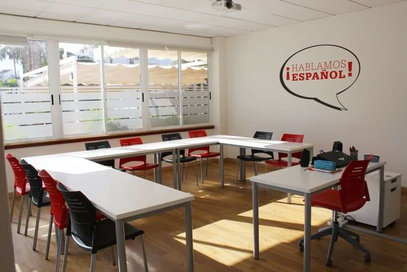 Een klaslokaal voor Spaanse taallessen, ingericht met tafels en stoelen.
