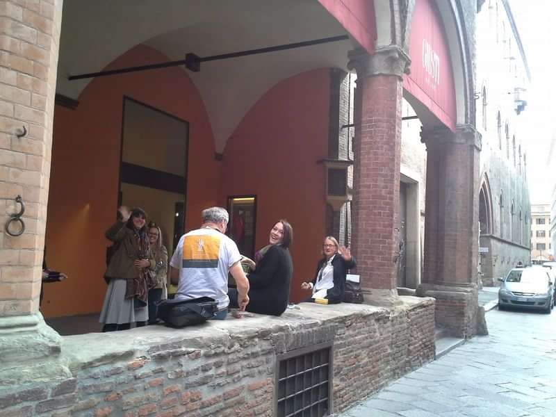 Group conversing in an archway, potential language immersion experience in Europe.
