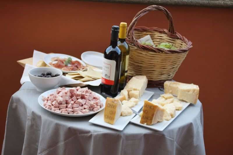 Italian culinary experience with various cheeses, meats, breads, and wine.