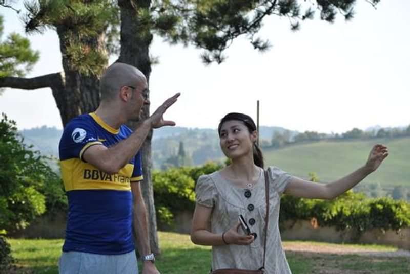 Twee mensen praten en gebaren in een landelijke omgeving, taaluitwisseling.