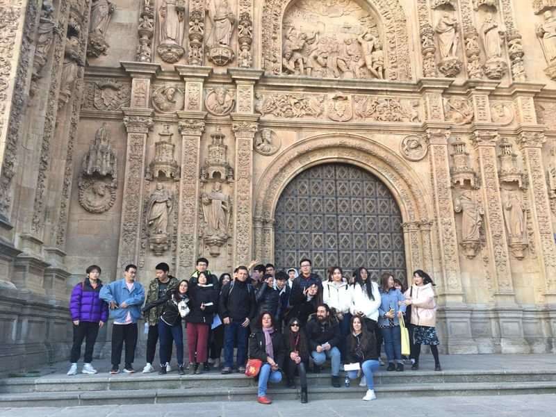 Group of students posing at historical architecture during language travel.