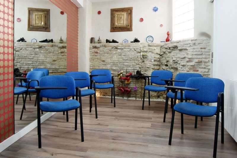 Classroom in language school, equipped with blue chairs and desks.