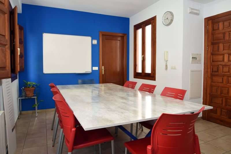 A classroom setup for language learning with whiteboard and chairs.