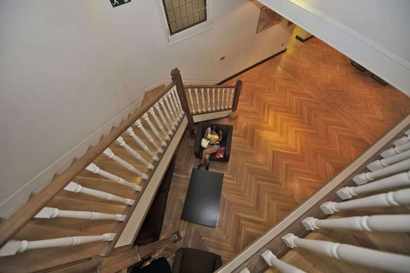 Staircase in a home, leading down to a wooden floor.