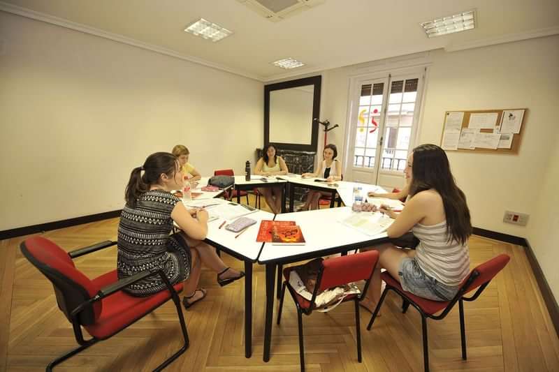 Studenten leren samen in een klaslokaal tijdens een taalcursus.