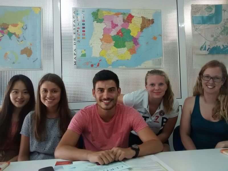 Group of language students in classroom with maps on the wall.