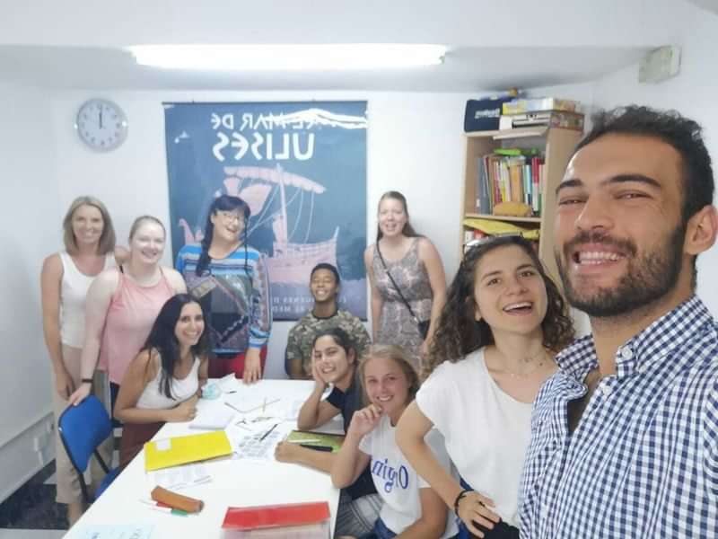 Language students at a travel immersion class, smiling and studying together.