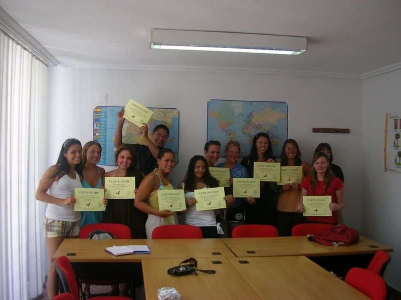 Group of students holding certificates in a classroom for language travel.