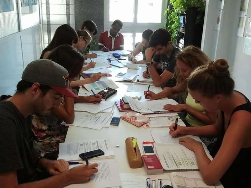 Students in a classroom focused on language learning activities abroad.