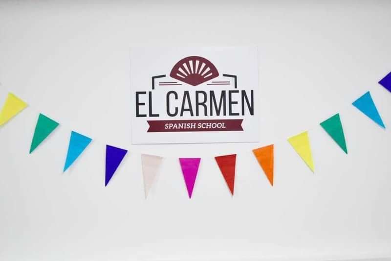 Spanish language school advertisement with colorful bunting decoration.