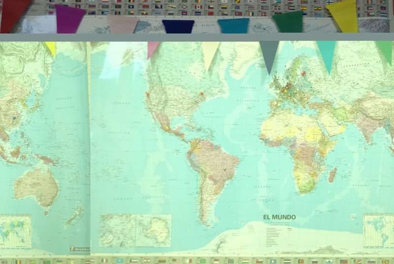 Wereldkaart met vlaggen er boven, gebruikt voor taalreizen.