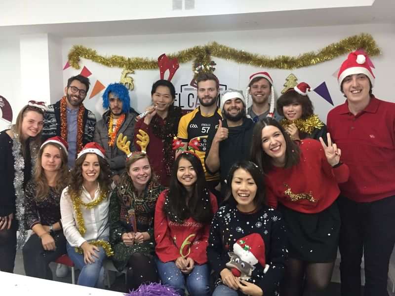 Group of diverse students in festive attire, celebrating in a language school.