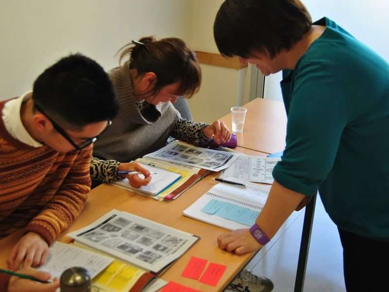 Students engaging in language learning activities at a desk.