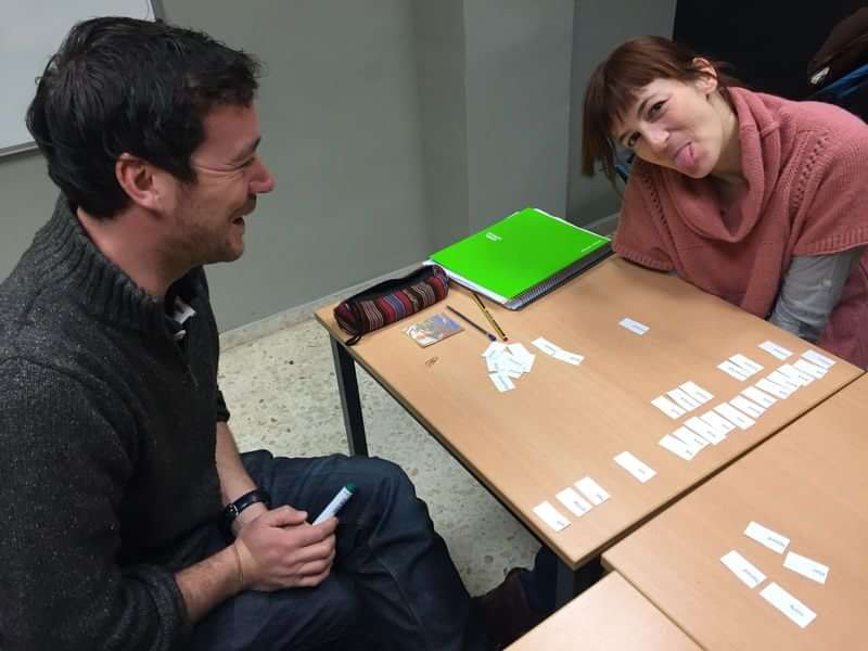 Students practicing language skills with word cards in a classroom.