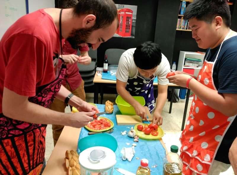 Language students are practicing cooking local cuisine together during cultural immersion.