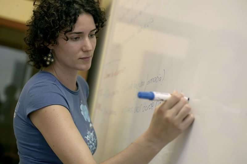 Lerares schrijft op whiteboard tijdens een taalles op reis.