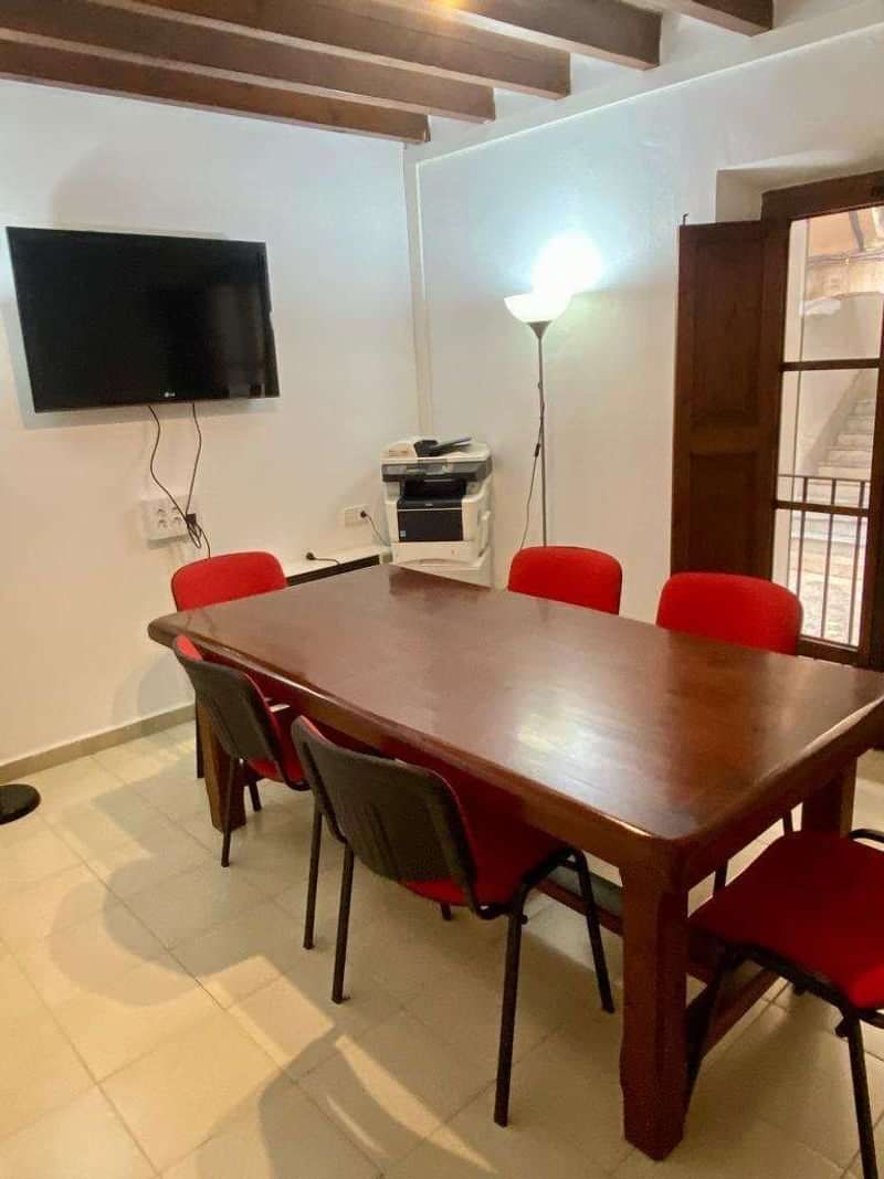 Meeting room in language school with red chairs and office equipment.