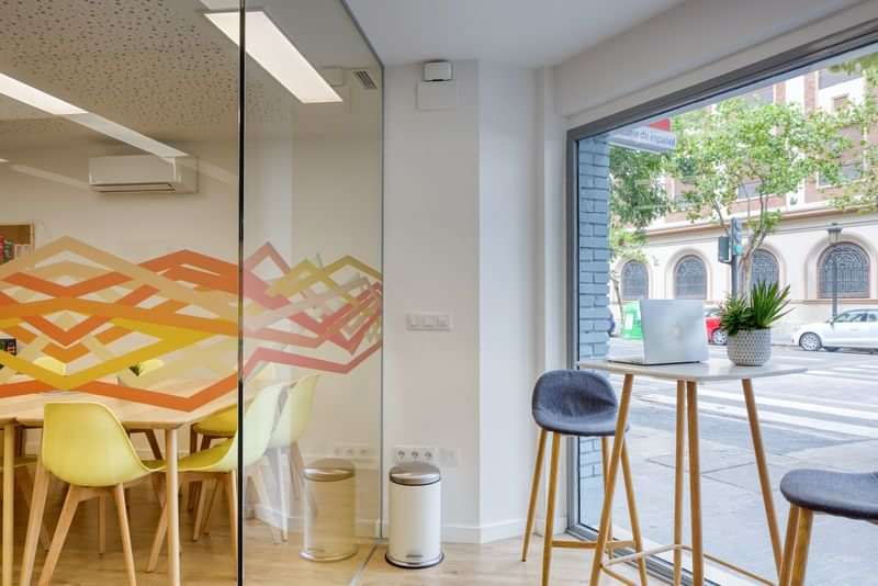 Modern classroom with glass walls and street view, inviting for learners.