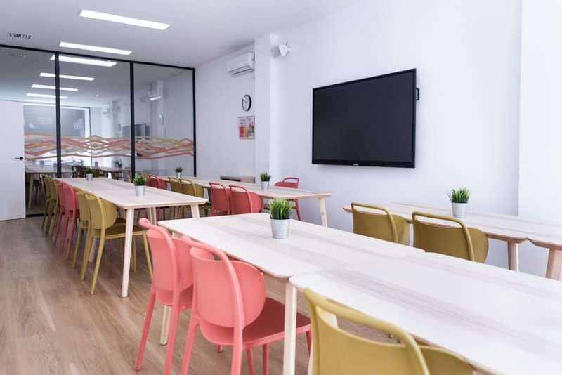 Modern classroom setup for language travel students with tables and chairs.