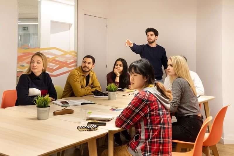 Group of students in a classroom, engaging in a language lesson.