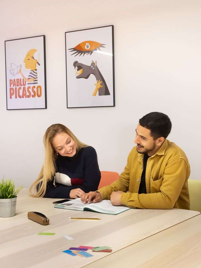 Two people studying together in a language learning setting.