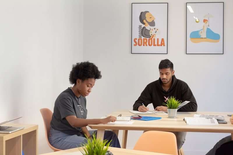 Two people studying at a language school, focused on learning materials.