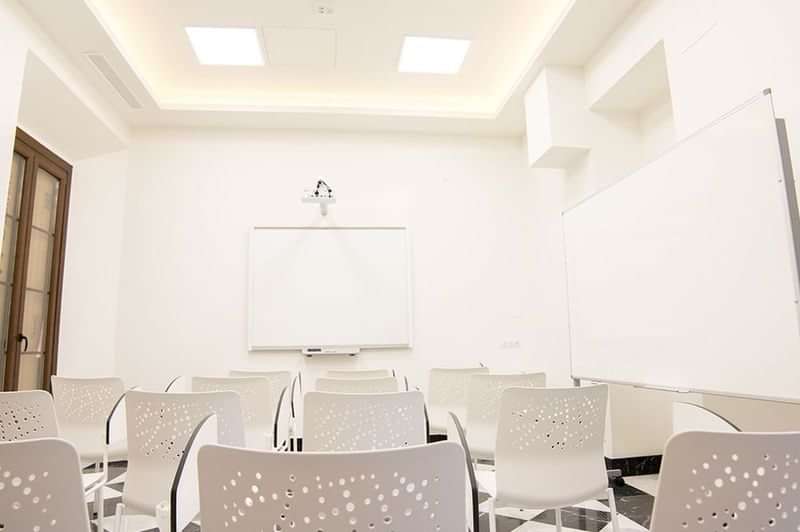 A classroom setup for language learning, with whiteboard and projector.