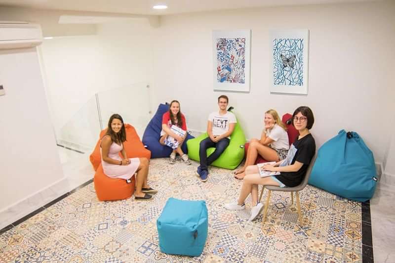 Students relaxing in a modern language school lounge with bean bags.