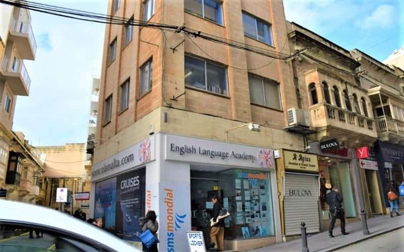 English Language Academy on a street corner in a city.