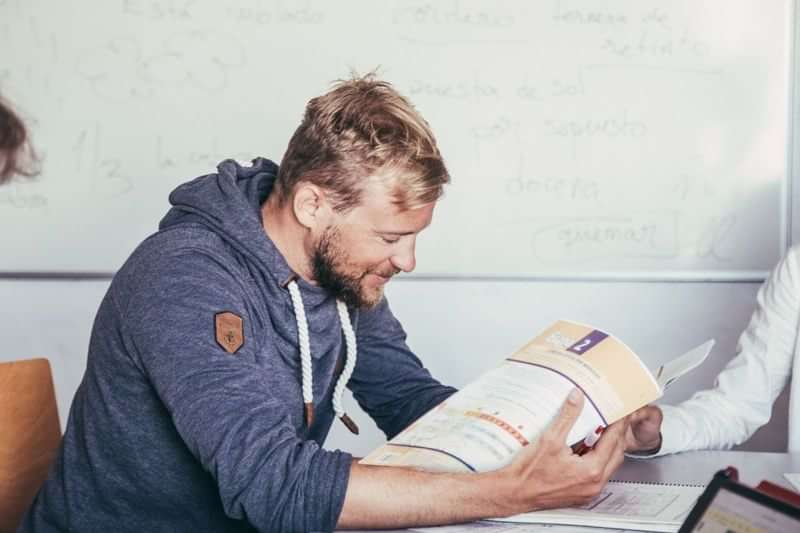 Man studying language materials, possibly in a foreign language class setting.