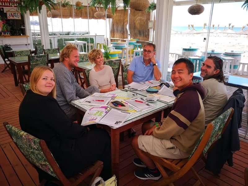 Group studying languages together in a tropical beachside setting.