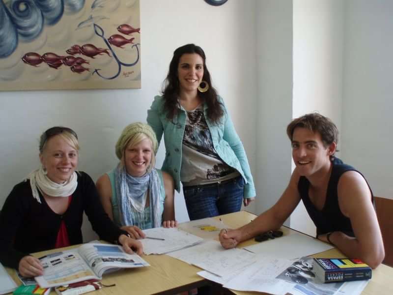 Group of people studying language with books and notes.