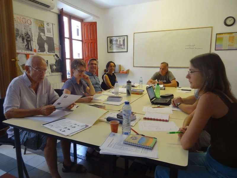 Een groep mensen volgt een taalcursus in een klaslokaal.