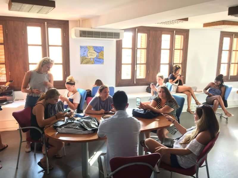 Studenten ontspannen in een gemeenschappelijke ruimte tijdens een taalreis.